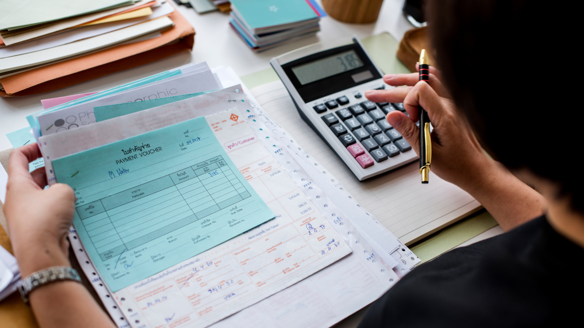 Plumber organising receipts and invoices with a calculator – simple bookkeeping without software