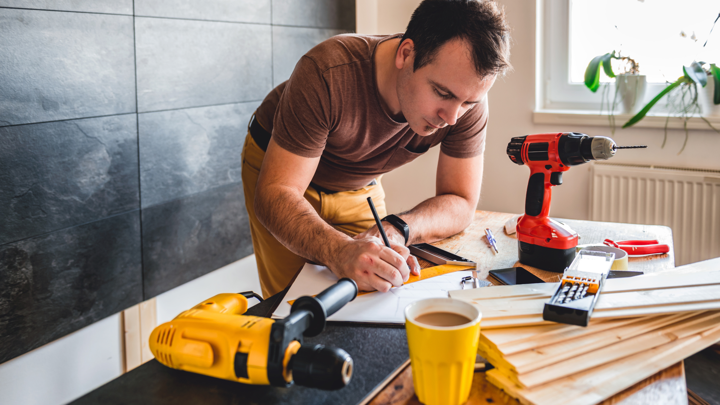 Tradesman working on site paperwork surrounded by tools and materials, representing CIS and PAYE tax record keeping.