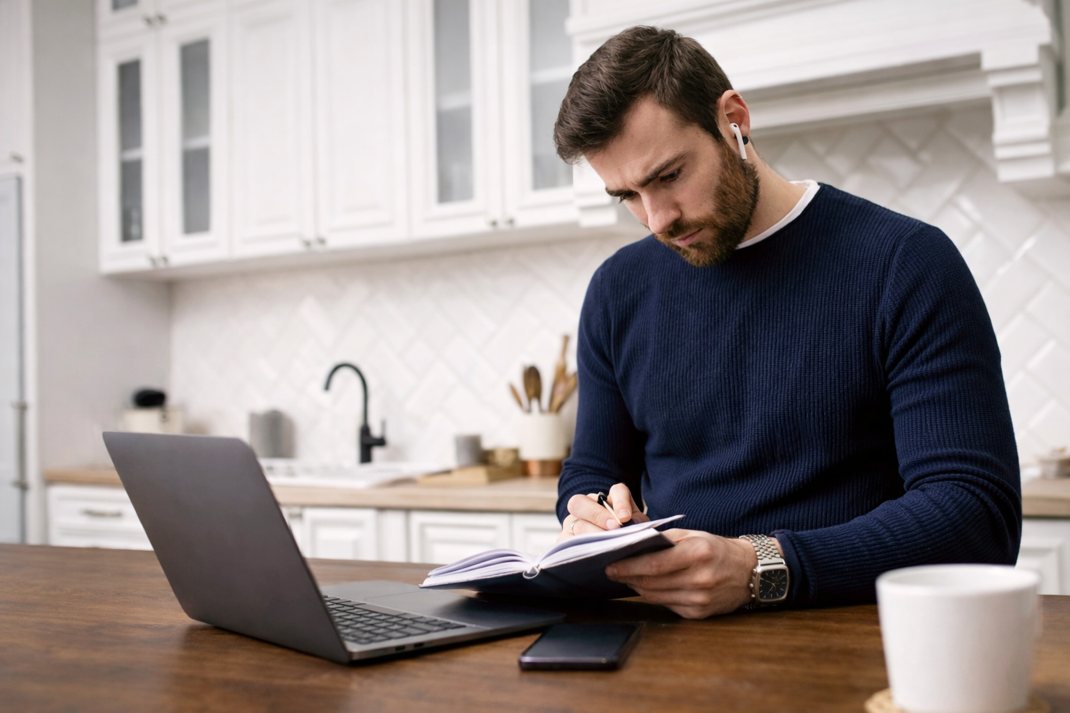 Individual reviewing financial notes and using a laptop at home during the final days before the UK tax year deadline.