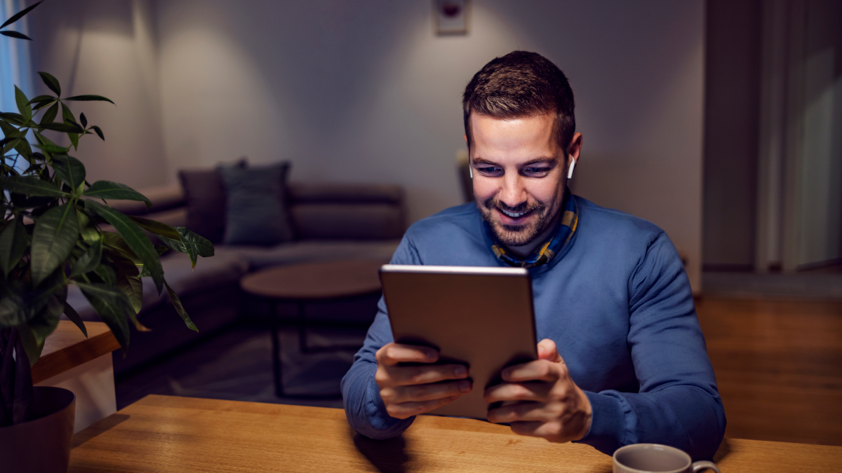 Individual using a tablet at home to review tax updates and manage digital records for HMRC compliance.