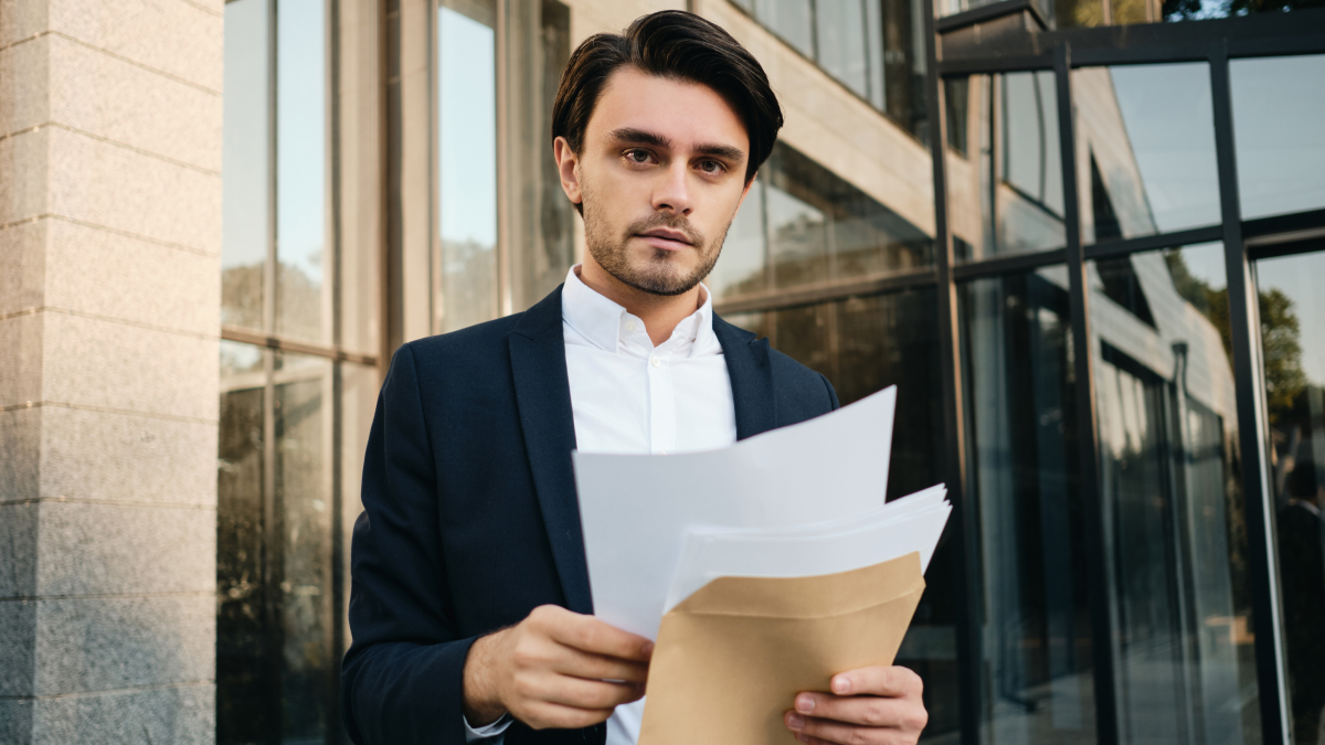 Self employed professional reviewing tax documents outside an office building before filing a Self Assessment tax return.