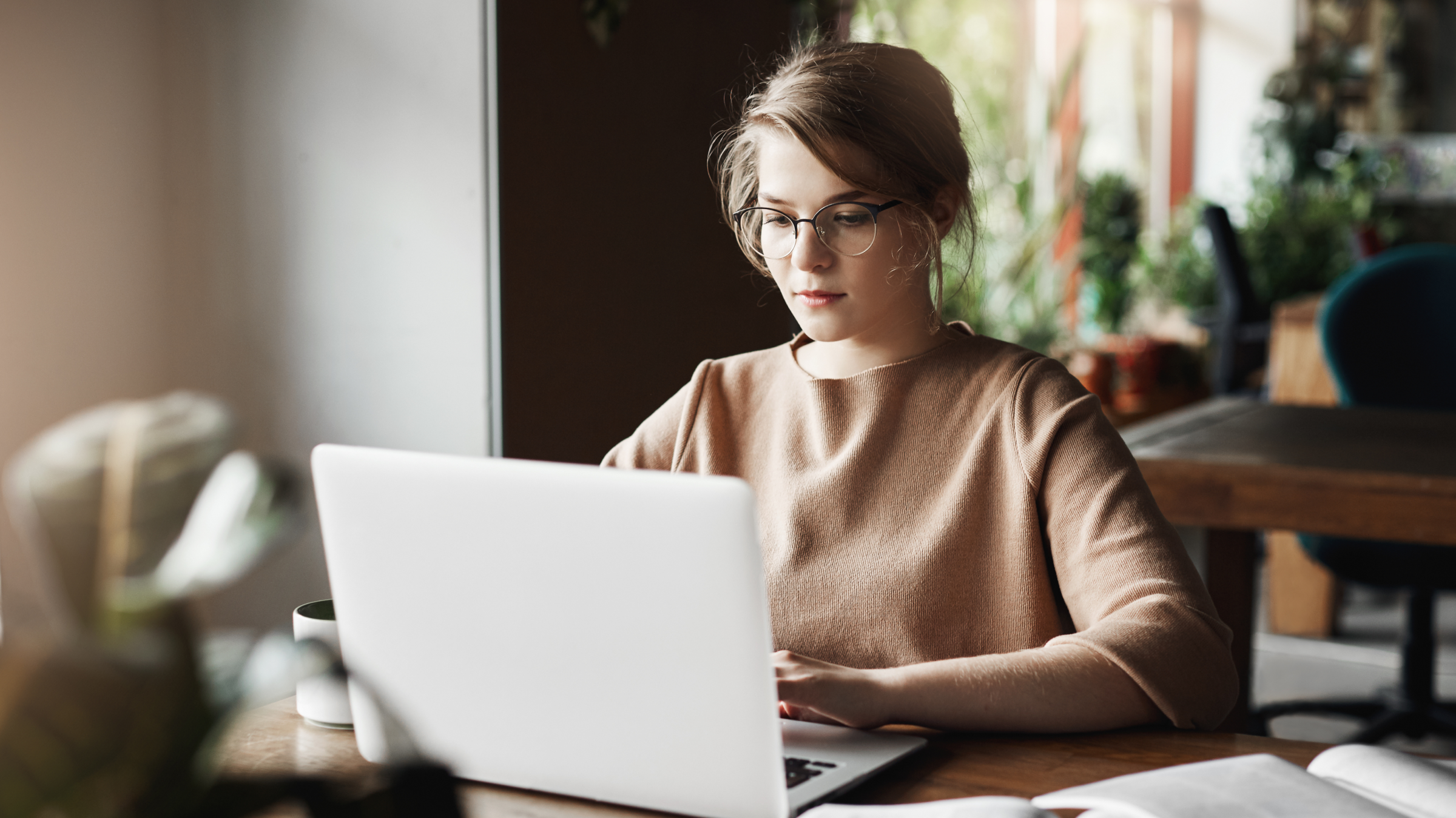A small business owner works on a laptop in a modern office, preparing digital business records for a Making Tax Digital quarterly submission before the HMRC deadline.