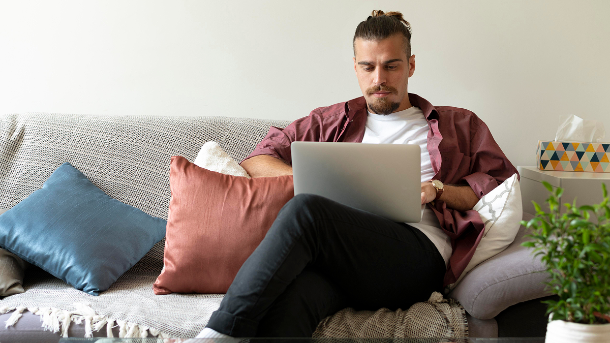 A self employed professional works on a laptop from home while reviewing business finances, representing mid year tax planning and financial preparation before the second half of the tax year.